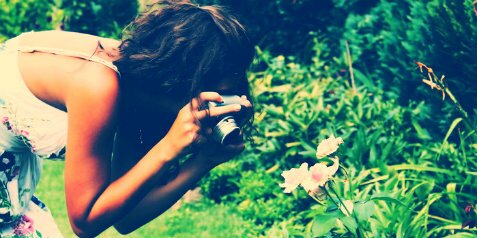 Девушка фотографирует цветок